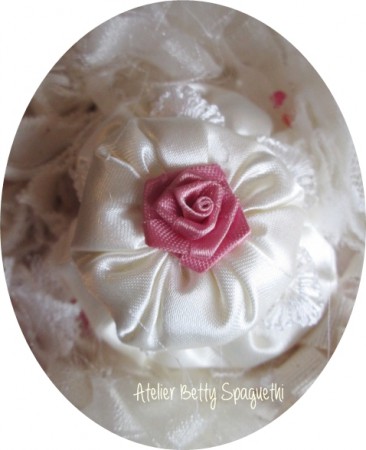 Bouquet Shabby Chic com rosas e peónias em cetim tom rosa velho, com apliques de bijuteria e plumas brancas. Pé forrado a cetim e renda branca com aplique prateado com pérola